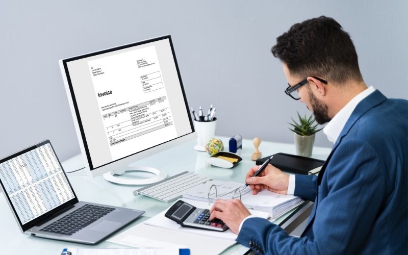 Accountant Making Invoice On Computer