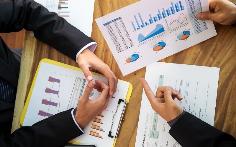 Business Meeting Over Financial Graphs