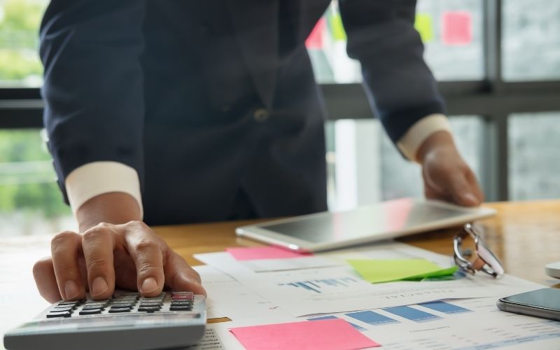 Businessman Hands Using a Calculator with Documents